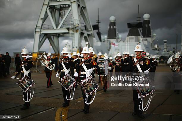 The band of the Royal Marines plays as HMS Illustrious arrives into Portsmouth Harbour on January 10, 2014 in Portsmouth, England. The ships returns...