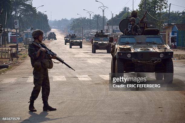 French soldiers part of the Sangaris operation patrol at the "Reconciliation crossroad" as unidentified shotguns fired in the area after the...