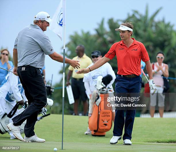 Joost Luiten of Netherlands shakes hands with his playing partner Rafa Cabrera-Bello of Spain on the 18th green after nearly hoiling his second shot...