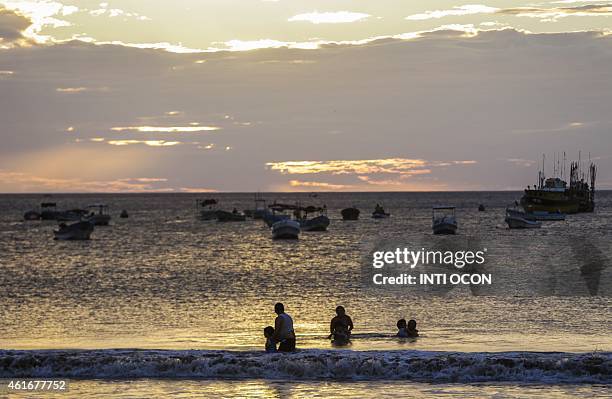 Family bathes on the beach of San Juan del Sur in Rivas, Nicaragua on January 16, 2015. AFP PHOTO/Inti OCON