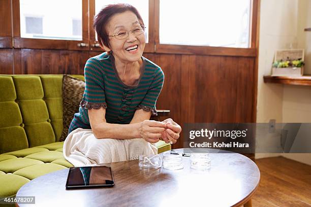 an senior woman making handicrafts at home - japanese old woman stockfoto's en -beelden