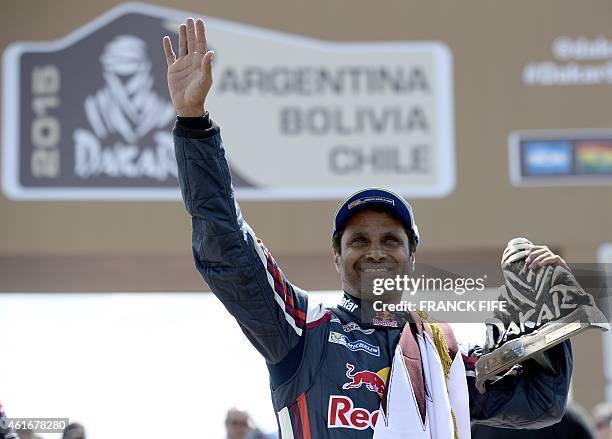 Mini's driver Nasser Al-Attiyah of Qatar holds the trophy on the podium of the 2015 Rally Dakar in Buenos Aires, Argentina on January 17, 2015....