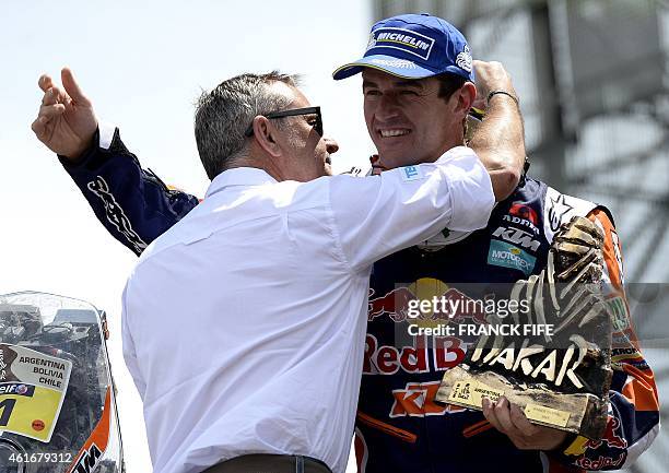 S Spanish biker Marc Coma receives his trophy from Dakar director Etienne Lavigne on the podium in Buenos Aires, Argentina, on January 17, 2015. Coma...