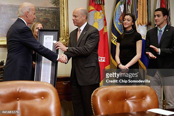 Vice President Joe Biden gives Homeland Security Secretary Jeh Johnson the framed roll call tally sheet of his confirmation vote after ceremonally...