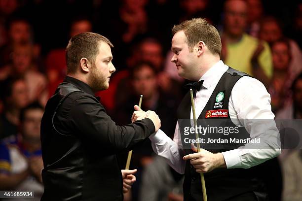 Shaun Murphy of Great Britain and Mark Allen of Northern Ireland shake hands after their semi-final match on day seven of the 2015 Dafabet Masters at...