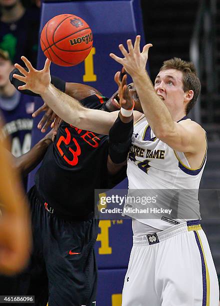 Tonye Jekiri of the Miami Hurricanes and Pat Connaughton of the Notre Dame Fighting Irish battle for a rebound at Purcell Pavilion on January 17,...