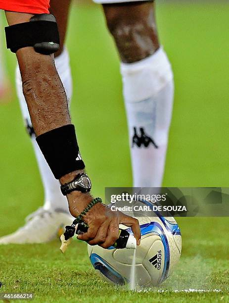 The referee sprays the line prior to a kick-off during the 2015 African Cup of Nations group A football match between Burkina Faso and Gabon at Bata...