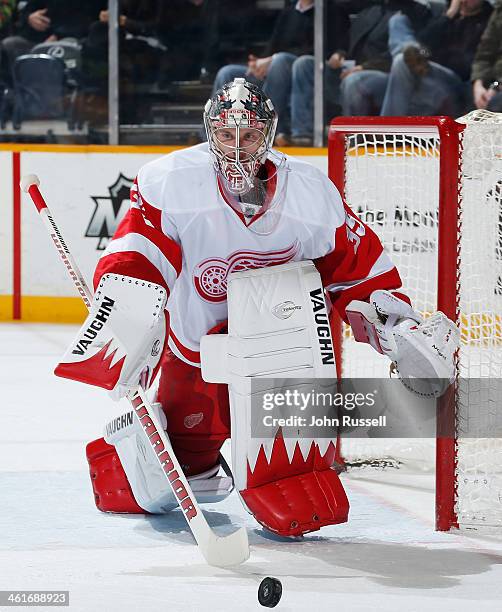 Jimmy Howard of the Detroit Red Wings plays the puck against the Nashville Predators at Bridgestone Arena on December 30, 2013 in Nashville,...