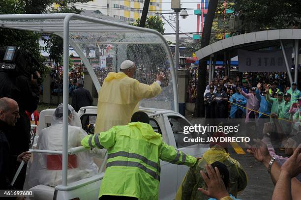 Pope Francis waves as he leaves following his visit to the University of Santo Tomas in Manila on January 18, 2015. Pope Francis will celebrate mass...