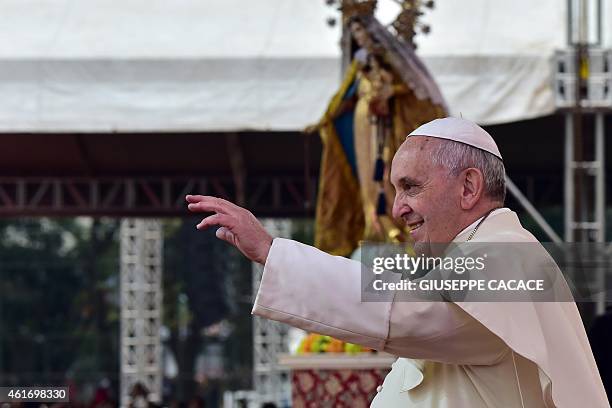 Pope Francis waves to devotees during his visit to the University of Santo Tomas in Manila on January 18, 2015. Pope Francis will celebrate mass with...