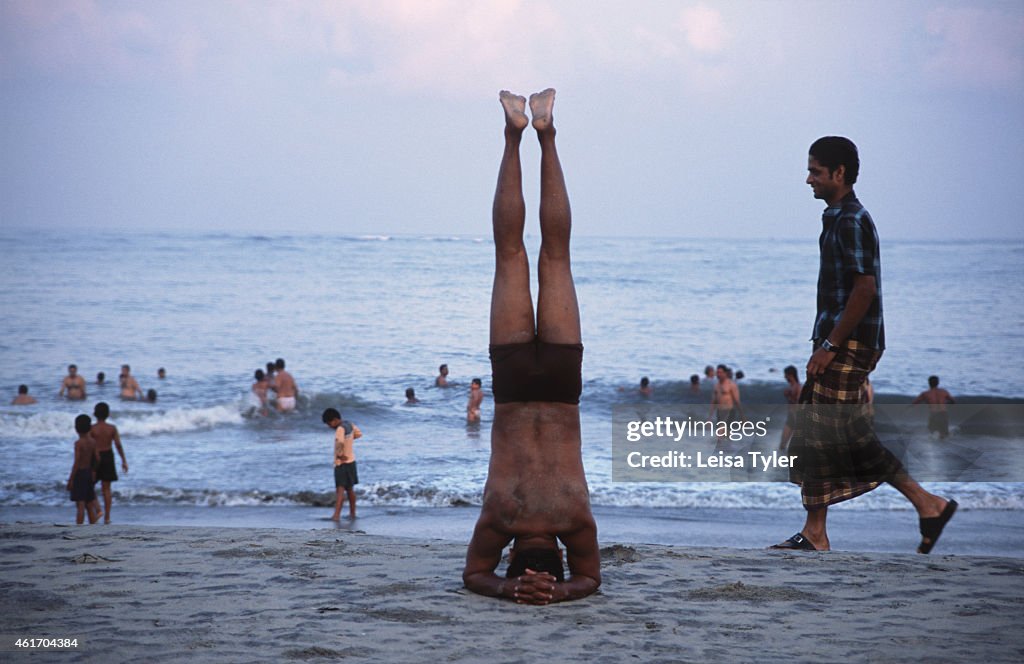 A man practicing an early morning head stand - a yoga asana...