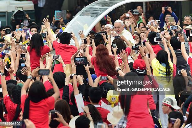 Pope Francis waves as he arrives at the University of Santo Tomas during his visit to Manila on January 18, 2015. Pope Francis later celebrated mass...