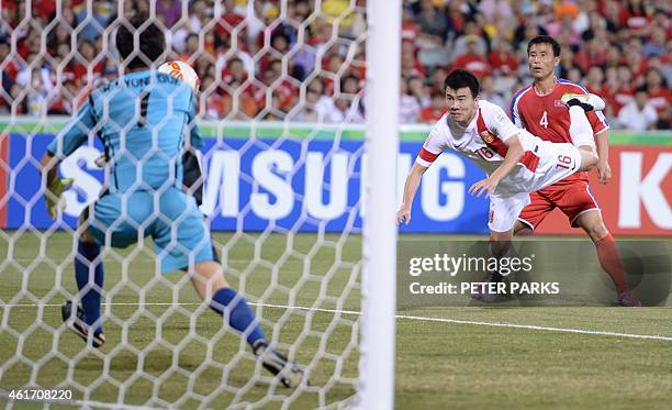 Sun Ke of China scores his second goal past North Korea's goalkeeper Ri Myong Guk as his teammate Jon Kwang Ik looks on during their Group B football...