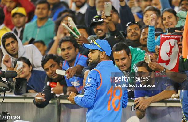 Virat Kohli of India signs autographs for supporters in the crowd during the One Day International match between Australia and India at the Melbourne...