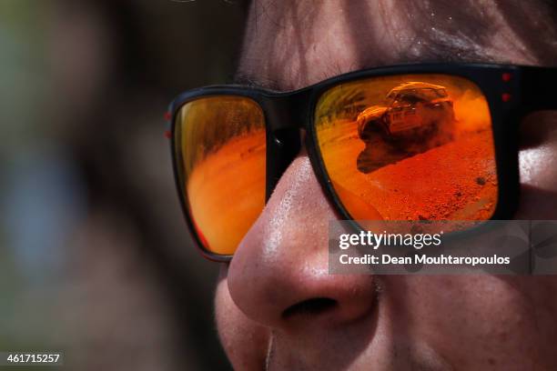 Local fan watches Nasser Al-Attiyah of Qatar and Lucas Cruz of Spain for MINI compete as seen in the reflection of his glasses during Day 6 of the...