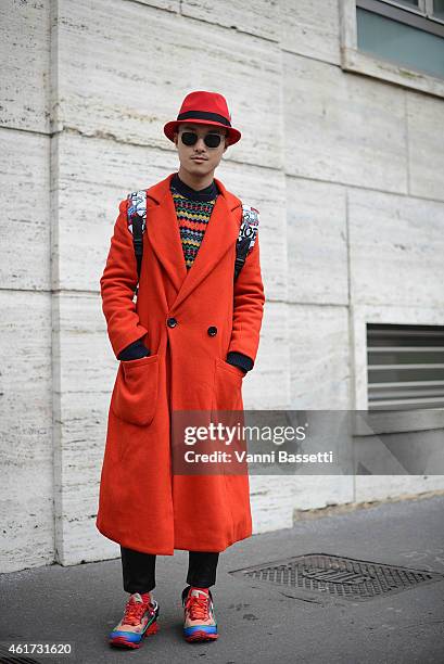 Peter Xu poses wearing a Topman Design coat, J Crew sweater, St. Laurent pants and Raf Simmons X Adidas shoes during day 2 of Milan Menswear Fashion...