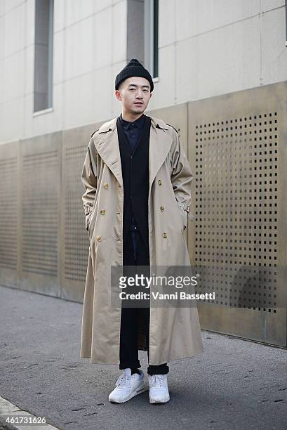 Evan Feng poses wearing a vintage trench, Prada suit and Nike shoes during day 2 of Milan Menswear Fashion Week Fall/Winter 2015/2016 on January 18,...