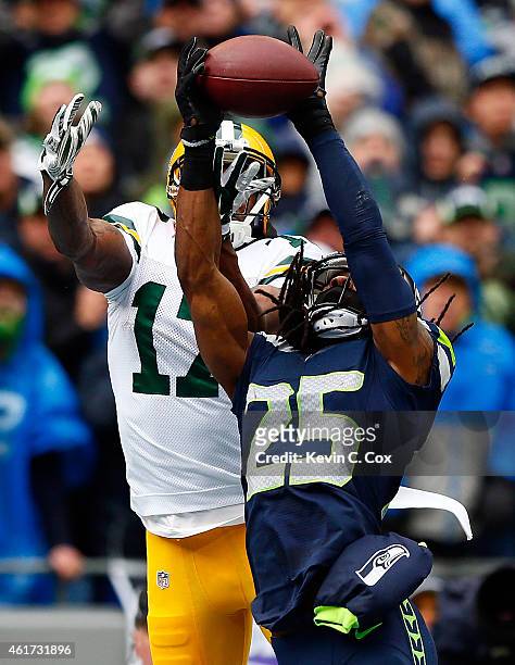 Richard Sherman of the Seattle Seahawks intercepts a pass intended for Davante Adams of the Green Bay Packers in the end zone during the first...