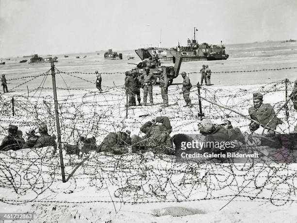 German prisoners are kept in an enclosure with barbed wire. 6th June 1944. They will later be taken to camps in England. Utah Beach, Normandy, France.