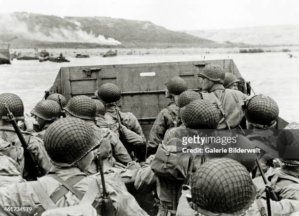 Soldiers watch the Normandy coast from a Landing Craft Vehicle, Personnel heading towards Omaha Beach Easy Red sector. 6th June 1944. Several...