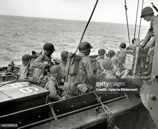 An assault unit completes boarding a Landing Craft, Vehicle, Personnel or the APA 26 USS Samuel Chase. 6th June 1944. GIs are wearing assault vests...