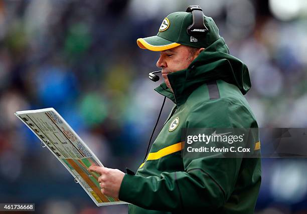 Head coach Mike McCarthy of the Green Bay Packers looks at his play sheet during the first half of the 2015 NFC Championship game against the Seattle...