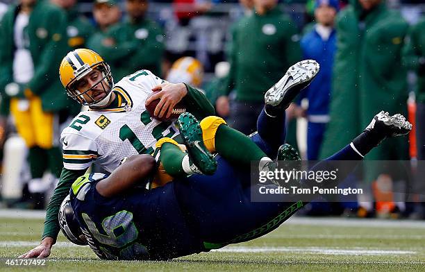 Cliff Avril of the Seattle Seahawks sacks Aaron Rodgers of the Green Bay Packers during the third quarter of the 2015 NFC Championship game against...