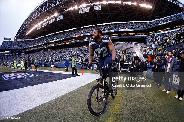 Michael Bennett of the Seattle Seahawks rides a police bike after the Seahawks 28-22 overtime victory against the Green Bay Packers during the 2015...