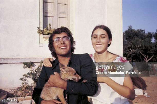 The italian singer Al Bano, born Albano Carrisi, smiles with his girlfriend Romina a Power and holds a dog. Cellino S.Marco, Italy, 1970