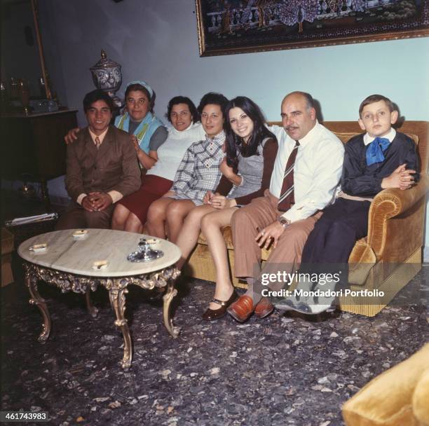 Rosanna Fratello in the sitting room at home, sitting on the sofa with her numerous family; the Italian actress and singer takes part to the Sanremo...