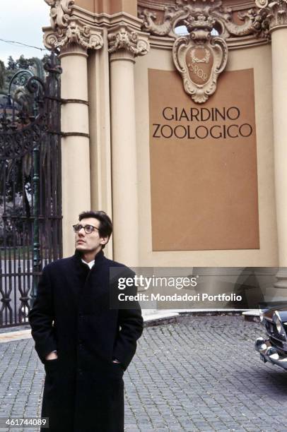 Dazed Milanese singer-songwriter and stand-up comedian Enzo Jannacci rests in front of the gate of a Roman zoological garden, where stands out an...