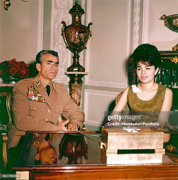 Wearing the military uniform, the last Emperor of Persia, Shah Mohammad Reza Pahlavi, is portrayed in the study of the Royal Palace with his third...