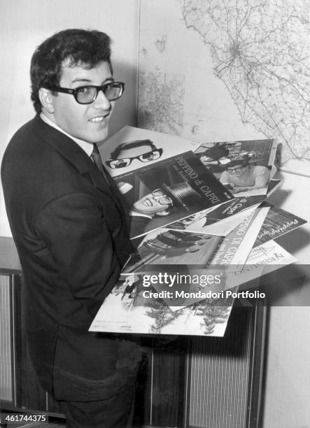 Peppino Di Capri, nom de plume of Giuseppe Faiella, smiles at the camera while keeping in his hands some of his most renowned albums; the Italian...