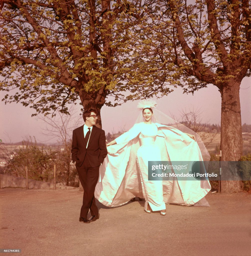 Peppino Di Capri and Roberta Stoppa wearing wedding dress and wedding suit pose in the open air