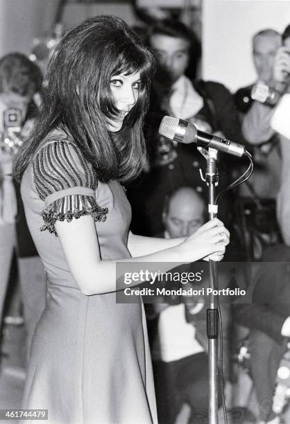 Italian actress Claudia Mori , taken on the stage of the Sanremo Music Festival during the performance of Chi non lavora non fa l'amore, glances...