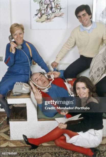 Italian actor Lino Banfi lying on a sofa pretending to speak on the telephone, with his wife Lucia Agresta and their children Walter Banfi and...