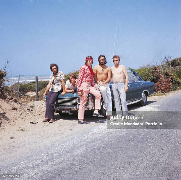 Italian band Nomadi posing leaned against a car. The band is composed by Italian singer Augusto Daolio, Italian keyboard player Beppe Carletti ,...