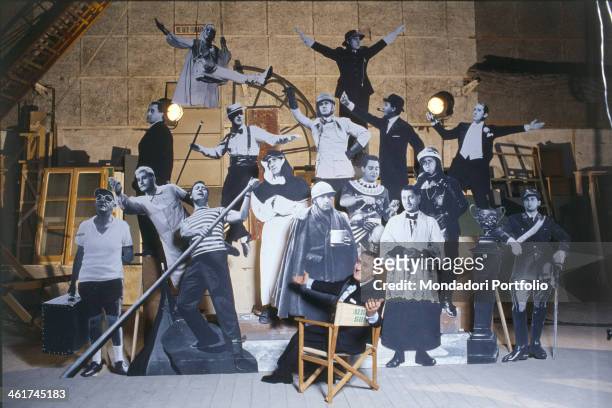 Italian actor, dubber and director Alberto Sordi sitting on a director's chair among the silhouettes depicting some of his characters, as the traffic...