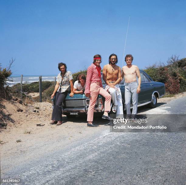 Italian band Nomadi posing leaned against a car. The band is composed by Italian singer Augusto Daolio, Italian keyboard player Beppe Carletti ,...