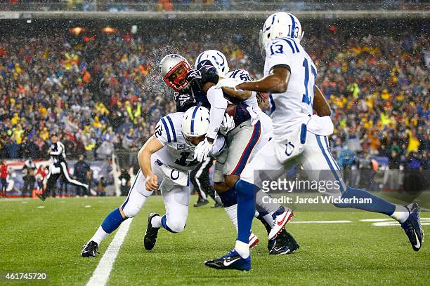 Darrelle Revis of the New England Patriots is tackled by Andrew Luck of the Indianapolis Colts after intercepting Luck's pass in the third quarter of...