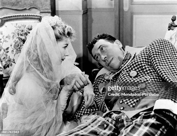 French actor and comedian Fernandel holding by the hand French actress Jacqueline Pagnol wearing a wedding dress in the film Carnaval. France, 1953