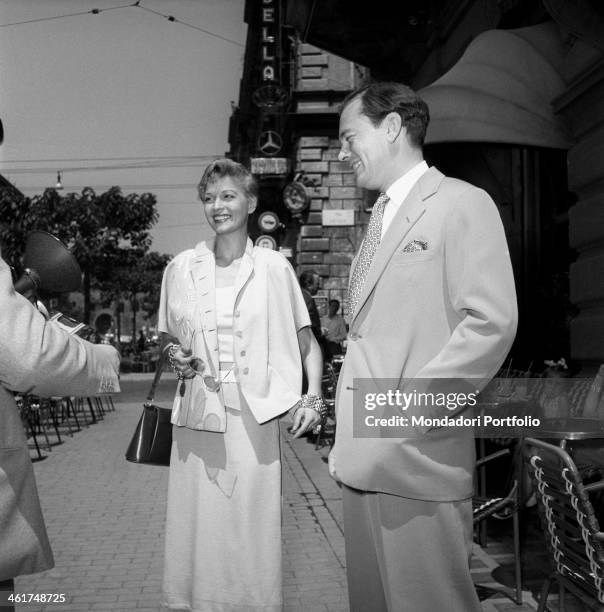 Young and smiling couple meets a photographer during a stroll in the city; they are the revue actress Isa Barzizza, well-known for her movies with...