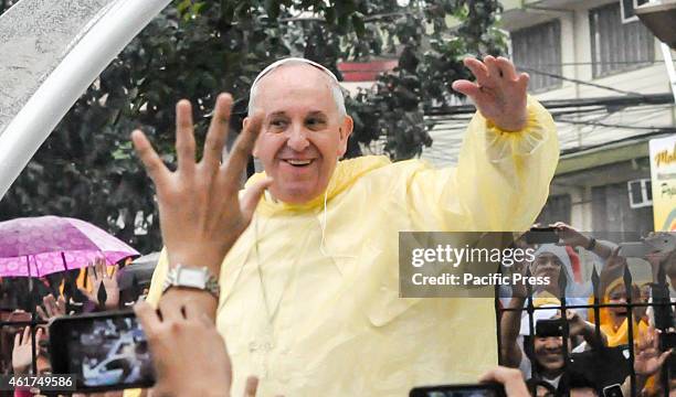 Pope Francis in his pope mobile waves to the crowd after the 'Encounter with Youth' at the University of Santo Tomas in Manila early morning on the...