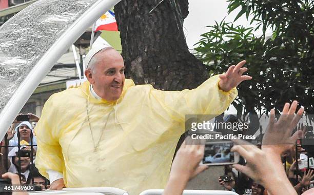 Pope Francis in his pope mobile waves to the crowd after the 'Encounter with Youth' at the University of Santo Tomas in Manila early morning on the...