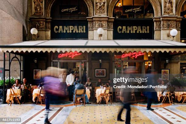 Some people sitting outside the Camparino café in the Galleria Vittorio Emanuele II. Milan, Italy. 2013