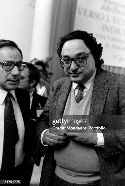 Italian politician Gianni De Michelis talking to a man during a public meeting. 1980s
