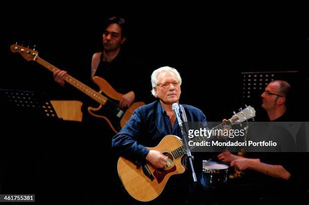 Italian singer-songwriter, actor and stand-up comedian Enzo Jannacci plays the guitar onstage the Condominio Theatre in Gallarate during the show The...