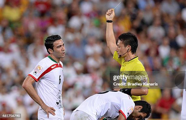 Javad Nekounam of Iran is given a yellow card by referee Ryuji Sato during the 2015 Asian Cup match between IR Iran and the UAE at Suncorp Stadium on...