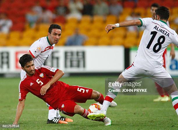 Amer Abdulrahman of United Arab Emirates tries to get the ball past Alireza Jahan Bakhsh of Iran as Javad Nekonam of Iran looks on during their Group...