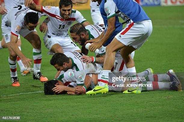 Team mates pile on to Reza Ghoochannejhad of Iran as they celebrate Ghoochannejhad goal against the United Arab Emirates during their Group C...